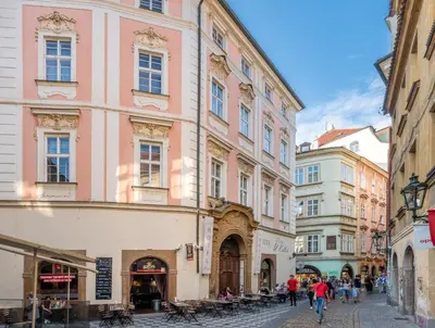 a group of people walking down a street with buildings at Hotel 