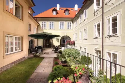 a courtyard of a building with an umbrella and flowers at Appia Hotel Residences in Prague