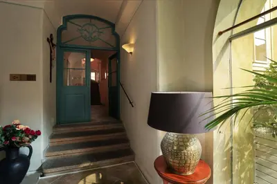 a hallway with a green door and a lamp on a table at Appia Hotel Residences in Prague