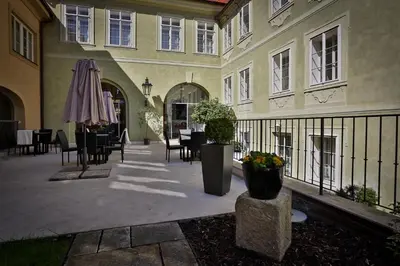 a courtyard with tables and chairs and an umbrella at Appia Hotel Residences in Prague