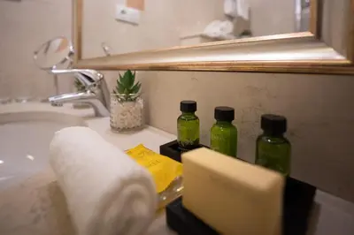 a bathroom sink with three green bottles on it at Appia Hotel Residences in Prague