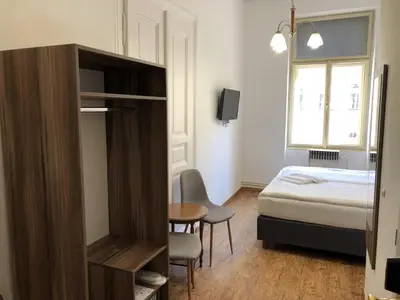 a bedroom with a bed and a desk and a table at Brezina Pension in Prague