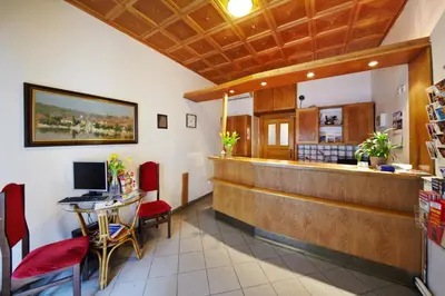 a restaurant with a counter and a table with a computer at Brezina Pension in Prague