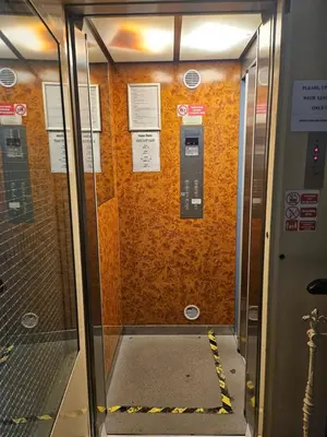 an elevator door with a cell phone on the wall at Brezina Pension in Prague