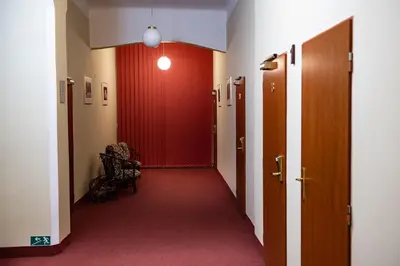 a hallway with a red door and a chair in a room at Hotel Petr in Prague