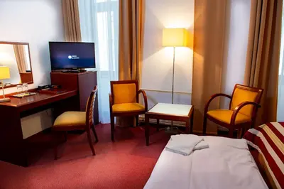 a hotel room with a bed and a desk and chairs at Hotel Petr in Prague
