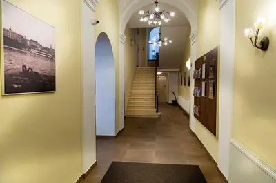 a hallway of a building with a staircase and a painting at Hotel Petr in Prague