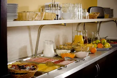 a kitchen counter with a bunch of food and milk at Hotel Petr in Prague