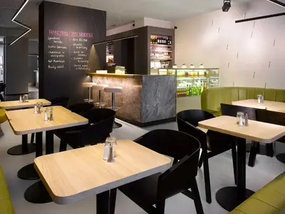 a restaurant with tables and chairs and a bar at The ICON Hotel in Prague