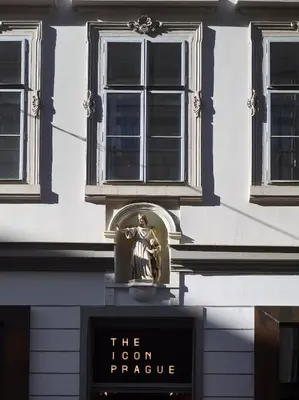 a sign in front of a building with a statue at The ICON Hotel in Prague