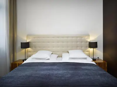 a bedroom with a large white bed with two lamps at The ICON Hotel in Prague