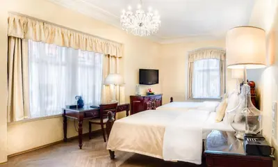 a bedroom with a bed and a desk and a chandelier at The Dominican in Prague