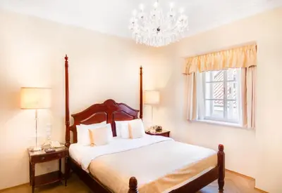 a bedroom with a bed and a chandelier at The Dominican in Prague