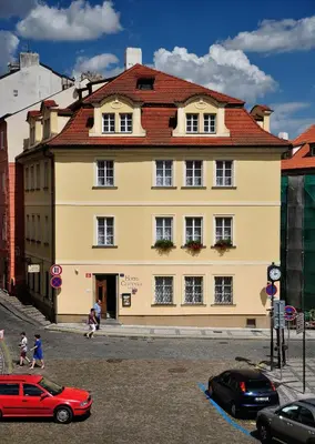 a large yellow building with a red roof at Hotel Certovka in Prague