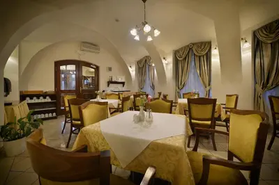 a restaurant with tables and chairs in a room at Hotel Certovka in Prague