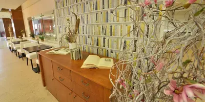 a library with books on the wall and a desk at Hotel Grand Litava Beroun in Beroun