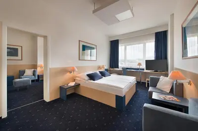 a hotel room with a bed and a couch at Hotel Grand Litava Beroun in Beroun
