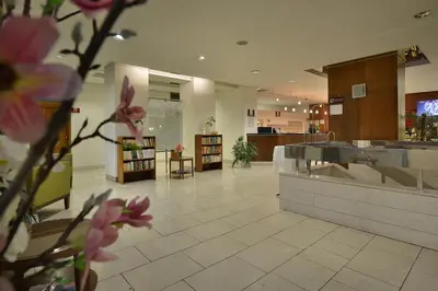 a lobby with a counter and flowers in a room at Hotel Grand Litava Beroun in Beroun