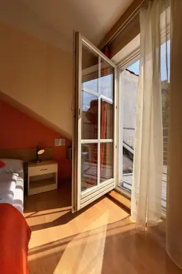 a bedroom with a large window with a view of a balcony at Residence Tabor in Prague