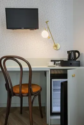 a desk with a chair and a television on a wall at Hotel Beránek in Prague