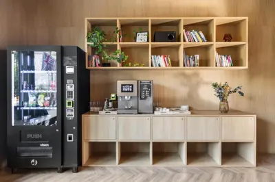 a coffee shop with a drink machine in a room at Hotel Beránek in Prague
