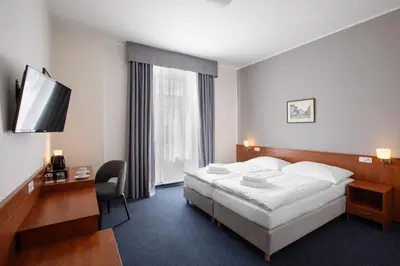 a hotel room with a bed and a television at Hotel Beránek in Prague
