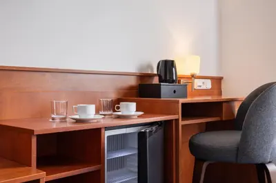 a desk with a chair and two cups and glasses at Hotel Beránek in Prague