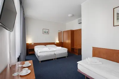 a hotel room with two beds and a table at Hotel Beránek in Prague