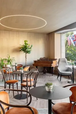 a restaurant with tables and chairs and a piano at Hotel Beránek in Prague