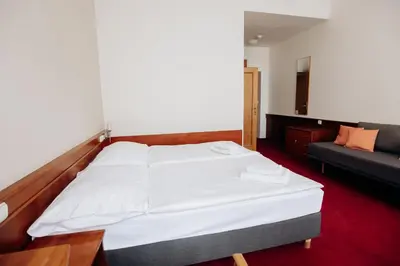 a bedroom with a large white bed and a couch at Alton in Prague