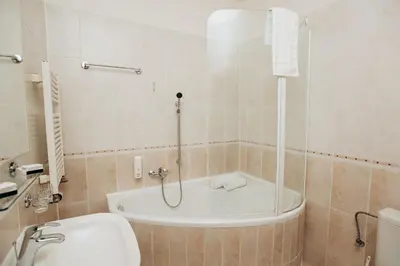 a bathroom with a tub and a toilet and a sink at Alton in Prague