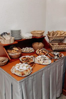 a table with plates of food and baskets of bread at Alton in Prague