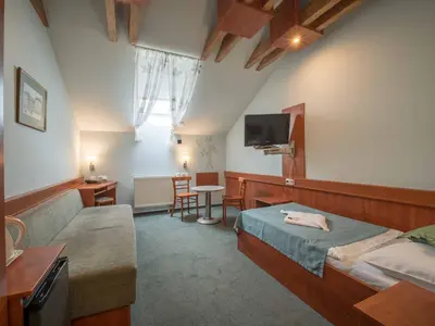a room with two beds and a couch and a tv at Alton in Prague