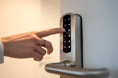 a hand pressing a button on an appliance at Little Tom Apartments in Prague