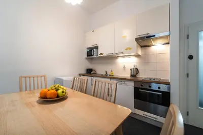 a kitchen with a wooden table with a bowl of fruit on it at Little Tom Apartments in Prague