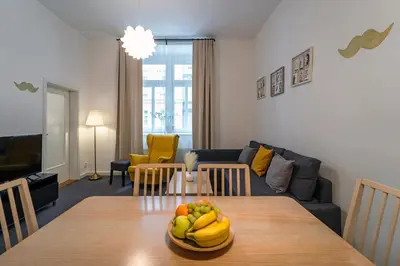 a living room with a table with a bowl of fruit on it at Little Tom Apartments in Prague