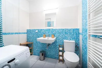 a blue and white bathroom with a toilet and a sink at Little Tom Apartments in Prague