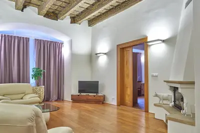a living room with a couch and a television at Hotel U 3 Pstrosu in Prague