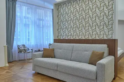 a living room with a couch and a large window at Hotel U 3 Pstrosu in Prague