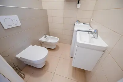 a white bathroom with a toilet and a sink at Hotel U 3 Pstrosu in Prague