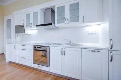 a white kitchen with white cabinets and a sink at Hotel U 3 Pstrosu in Prague