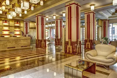 a lobby with a chair in the middle of a building at Majestic Plaza Hotel Prague in Prague