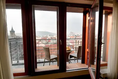 a balcony with chairs and a view of a city at Majestic Plaza Hotel Prague in Prague