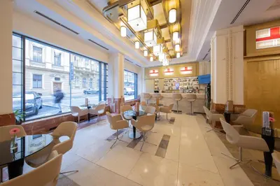 a restaurant with tables and chairs in a room with windows at Majestic Plaza Hotel Prague in Prague