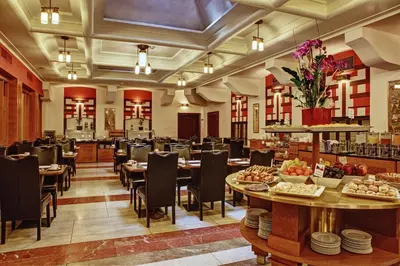 a restaurant with tables and chairs and a buffet at Majestic Plaza Hotel Prague in Prague