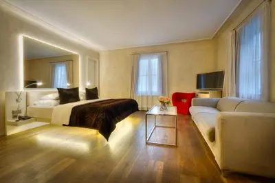 a hotel room with a bed and a couch at Three Storks in Prague