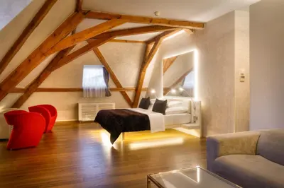 a bedroom with a bed and a couch in a attic at Three Storks in Prague