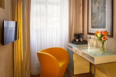 a hotel room with a desk and a yellow chair at Three Storks in Prague