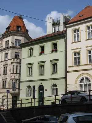 a white building with red flowers in the windows at Zderaz in Prague