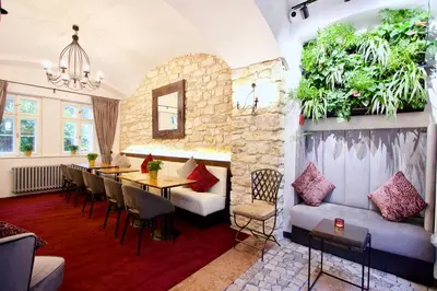 a dining room with a table and chairs and plants on the wall at Hotel Residence Agnes in Prague